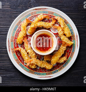 Frittierte, panierte Tempura Garnelen Garnelen mit Sauce auf schwarz verbrannten Holz Hintergrund Stockfoto