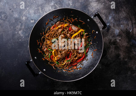 Stir-Fry Soba-Nudeln mit Rindfleisch und Gemüse im Wok-Pfanne auf dunklem Hintergrund Stockfoto