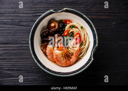 Ramen-Nudeln mit Garnelen und Shiitake Pilze auf dunklem Holz Stockfoto