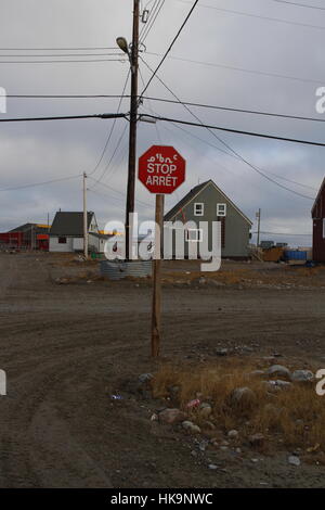 Mehrsprachige Stoppschild in Englisch, Französisch und Inuktitut in Arviat, Nunavut Stockfoto