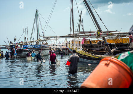 Menschen Schnäppchen für besseren Preis, Fisch in einer lokalen Fischmarkt am alten Dhow Hafen, Sansibar-Stadt, Sansibar, Tansania zu kaufen. Fischer bringen Fisch auf den Markt für Händler, wie sie Fisch zu verkaufen es auf dem Markt von Stone Town zu kaufen. Stockfoto