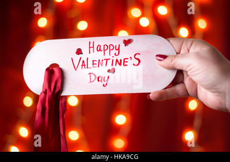 Weibliche Hand mit Happy Valentines Day Karte Stockfoto