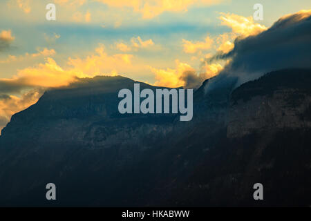 Sonnenlicht bricht durch die Wolken über einen Berg in den Alpen Stockfoto
