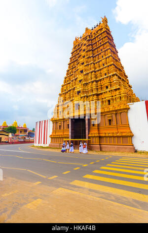 Bevölkerung auf der Straße vor goldenen Gopuram Eingangsturm, Vaasal Swarna in Nallur Kandaswamy Kovil Tempel Sri Lankas Stockfoto