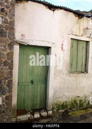 Altes Haus mit verblassten gemalte grüne Front Holztür Pagi Village, Korfu, Griechenland Stockfoto