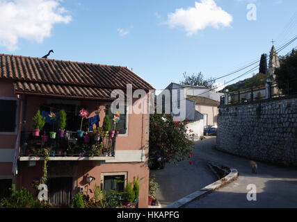 Hauptstraße durch Pagi Dorf, Korfu, Griechenland mit Haus mit bunten Balkon links Stockfoto