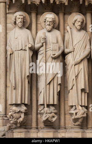 Apostel Bartholomäus, St. Simon der Zelot und St James desto weniger (von links nach rechts). Neo-gotischen Statuen an der Hauptfassade der Kathedrale Notre-Dame (Notre-Dame de Paris) in Paris, Frankreich. Beschädigte gotische Statuen an der Hauptfassade wurden in den 1840er Jahren von französischen Architekten Eugene Viollet-le-Duc und Jean-Baptiste Lassus restauriert. Stockfoto