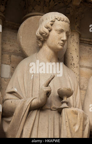 Johannes der Evangelist. Neo-gotische Statue an der Hauptfassade der Kathedrale Notre-Dame (Notre-Dame de Paris) in Paris, Frankreich. Beschädigte gotische Statuen an der Hauptfassade wurden in den 1840er Jahren von französischen Architekten Eugene Viollet-le-Duc und Jean-Baptiste Lassus restauriert. Stockfoto