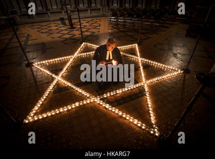 Canon Kanzler Christopher Collingwood hilft Licht 600 Kerzen in der Form der Davidstern zum Holocaust-Gedenktag am York Minster, York Gedenken an. Stockfoto