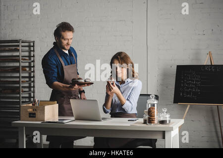 Mann mit Gebäck, junge Frau Stockfoto
