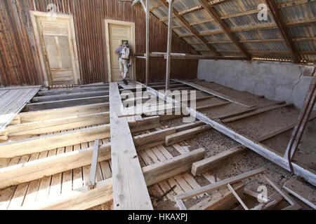 Tourist in einem der verlassenen Häuser in Kolmanskop Diamant Bergbaustadt in Namibia Stockfoto