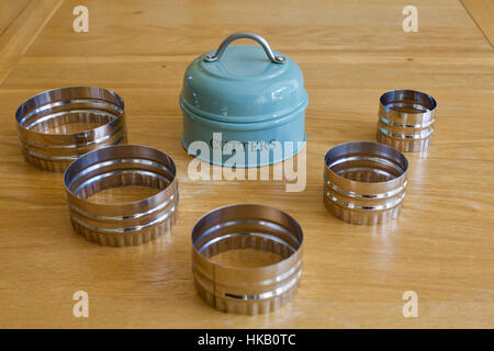 Satz von traditionellen 5 fünf Keks Ausstechformen angelegt auf einem Holztisch in der Küche mit Metallhalter Stockfoto