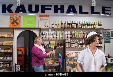 Dresden, Deutschland. 27. Januar 2017. Katrin Riedel steht in einem Kaufhaus Imitaded aus der DDR in der Ausstellung "Sterben Welt der DDR" (lit.) "Die Welt der DDR") in Dresden, Deutschland, 27. Januar 2017. Die Ausstellung präsentiert Exponate aus allen Bereichen des Lebens in der ehemaligen DDR und öffnet am 29. Januar 2017. Foto: Sebastian Kahnert/Dpa-Zentralbild/Dpa/Alamy Live News Stockfoto