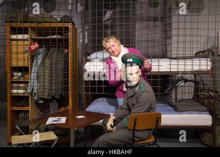 Dresden, Deutschland. 27. Januar 2017. Katrin Riedel korrigiert den Hut einer Marionette in der Uniform eines Soldaten der NVA in der Ausstellung "Sterben Welt der DDR" (lit.) "Die Welt der DDR") in Dresden, Deutschland, 27. Januar 2017. Die Ausstellung präsentiert Exponate aus allen Bereichen des Lebens in der ehemaligen DDR und öffnet am 29. Januar 2017. Foto: Sebastian Kahnert/Dpa-Zentralbild/Dpa/Alamy Live News Stockfoto