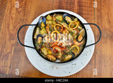 Traditionelle spanische Meeresfrüchte-Eintopf (Cazuela de Mariscos) serviert auf Holztisch Stockfoto