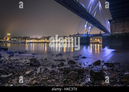 Hungerford und Golden Jubilee Bridge gesehen von Thames River Strand bei Ebbe Stockfoto