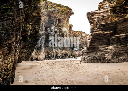 Sandstein auf einem Sandstrand im Atlantik Spanien. Blauer Himmel mit Wolken über tropischen Strand mit Sand im Mittelmeer, Tropic oder Atlantic se Stockfoto