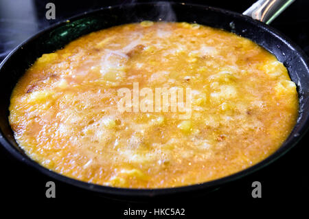 Making-of spanische Tortilla spanisches Omelett Tortilla de Patata. Typisch spanisches Omelett Gericht oder Tapas mit Eiern, Kartoffeln, Zwiebeln und Olivenöl Stockfoto