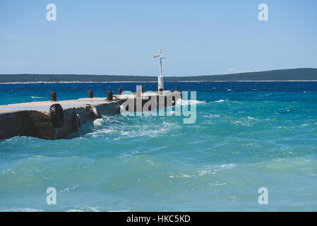 Starke Winde und Wellen schlagen einer Mole im Hafen. Hafen in Kroatien Insel Silba ist schlechtes windigem Wetter erleben. Stockfoto