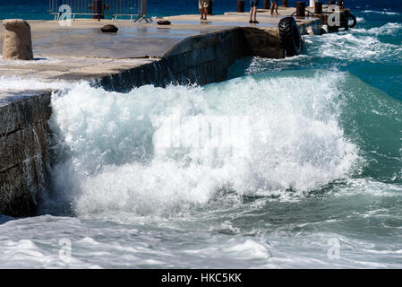 Starke Winde und Wellen schlagen einer Mole im Hafen. Hafen in Kroatien Insel Silba ist schlechtes windigem Wetter erleben. Menschen sind große Wellen genießen. Stockfoto