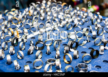 Zeigen Sie mit unterschiedlichen Designs handgefertigt Silber Ringe auf blauem Stand an. Nahaufnahme der handgemachten Schmuck Shop Schaufenster. Stockfoto