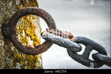 Alten rostigen Anker Schiff Eisenkette in Hafen am Meer. Alten Zaun aus veralteten Boot Kettenelemente mit Meer Ozean im Hintergrund. Stockfoto