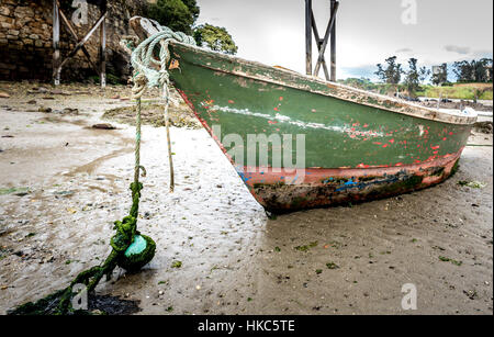 Altes Fischerboot liegt am Strand bei Ebbe in Santa Cruz Island, Oleiros, Rias Altas, A Coruña, Spanien. Stockfoto