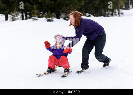 Professionelle Ski-Lehrer lehrt eine Kind an einem sonnigen Tag auf einem Hang Bergresort mit Sonne und Schnee Ski zu fahren. Familie und Kinder aktiv vacati Stockfoto