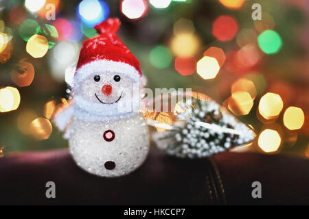 kleine Schneemann auf unscharfen Lichter Hintergrund Stockfoto