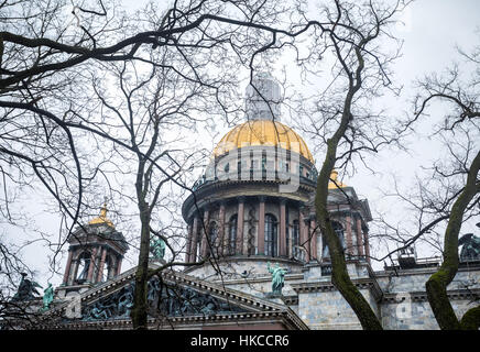 Berühmte Isaak Kathedrale und alten Eichen am dramatischen grauen Himmel in St. Petersburg, Russland Stockfoto