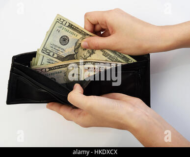 Person, die zwanzig Dollar Geld aus schwarzen Brieftasche Stockfoto
