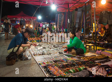 LUANG PRABANG, LAOS - 15. Mai 2015: Ein Tourist sucht nach Souvenir in Luang Prabang Nachtmarkt, einem erstklassigen Reiseziel in Laos. Stockfoto