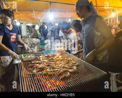 Krabi, Thailand - 20. Dezember 2015: Ein Mann bereitet BBQ Garnelen in der beliebten Nachtmarkt von Krabi in Thailand. Stockfoto