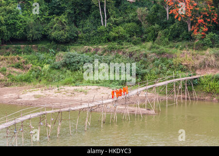 LUANG PRABANG, LAOS - 16. Mai 2015: Buddhistische Mönche eine Holzbrücke überqueren, am Fluss Nam Ou in Luang Prabang im Norden Laos Stockfoto