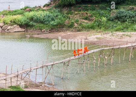 LUANG PRABANG, LAOS - 16. Mai 2015: Buddhistische Mönche eine Holzbrücke überqueren, am Fluss Nam Ou in Luang Prabang im Norden Laos Stockfoto