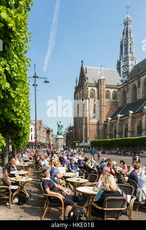 HAARLEM, Niederlande - 27. Mai 2016: Menschen genießen Sie Getränke auf einer Caféterrasse auf dem Grote Markt-Platz im Zentrum von Haarlem mit Blick auf den großen Stockfoto