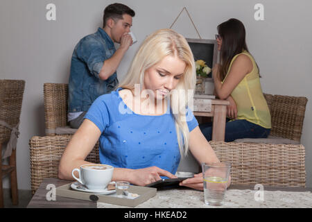 Blonde stolz Business-Frau sitzt mit Tablet im Acafeteria mit Kaffee und Wasser Stockfoto