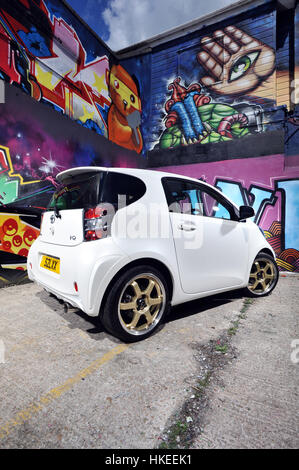 Modifizierte Toyota IQ Sub kompakten Auto und Graffiti Stadtmauer Stockfoto