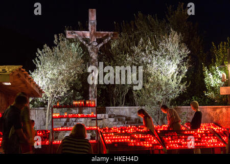 Pilger kommen, um eine Kerze vor dem Kreuz in der Nähe der St. James Kirche anzuzünden. Stockfoto