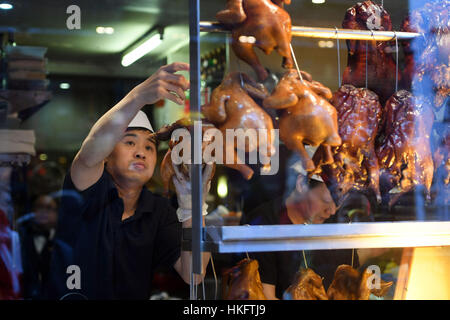 Ein Koch bereitet knusprige Ente in einem Schaufenster an der Gerrard Street wie in Chinatown, London, vor dem chinesischen Neujahrsfest am Wochenende vorbereitet sind. Stockfoto