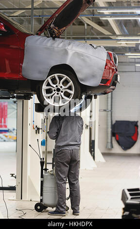Mechaniker, die Aussetzung im Auto in großen und sauberen Garage reparieren Stockfoto