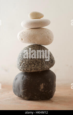 Ein Stapel von Kieselsteinen in verschiedenen Tönen vor einem rustikalen Hintergrund Stockfoto