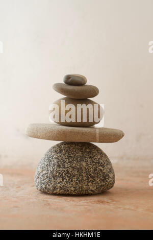 Ein Stapel von Steinen mit Grautönen auf einem rustikalen Hintergrund Stockfoto