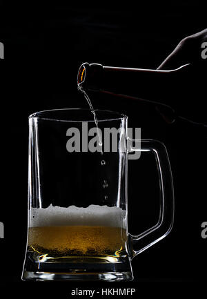 Bier Flasche im leeren Glas schwarz Komm Stockfoto