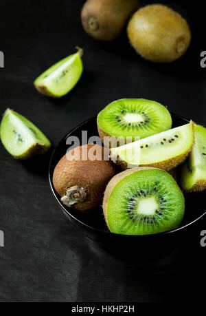 Kiwi Fruchtsalat in einer Schale auf einem schwarzen Stein Tisch Stockfoto