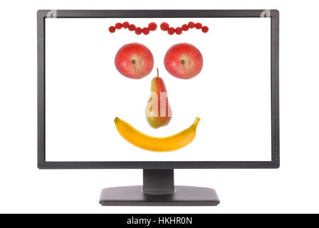 Computer-Monitor auf weißem Hintergrund. Lustiges Gesicht aus Obst auf weiße Leinwand hergestellt. Clipping-Pfad enthalten. Separate Clipping-Pfad auf dem Bildschirm Stockfoto