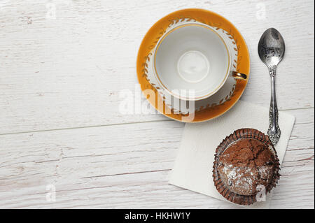 leere Tasse mit Tasse Kuchen auf Holztisch Stockfoto