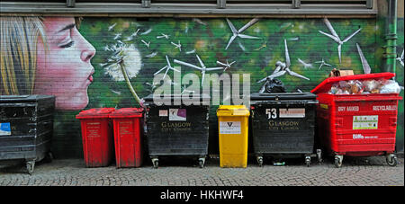 Graffiti in Glasgows Hinterstraße, blonde Frau bläst einen Löwenzahn in Windturbinen, erzeugt grüne Energie, in der Nähe von Mülltonnen Stockfoto