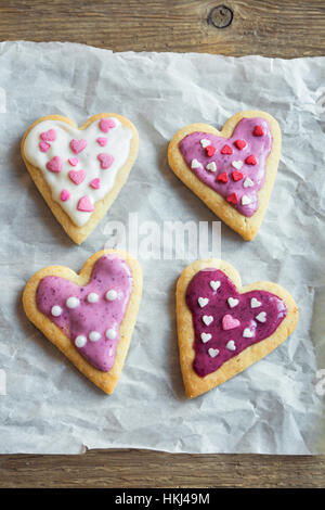 Herzförmige Cookies schließen für Valentinstag - selbstgemachter festlich dekorierten Kuchen Buiscuits Cookies auf Backpapier, Valentinstag Liebe Konzept Stockfoto