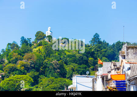 Fernen, weiße Bahiravokanda Vihara Buddhastatue auf Straße oder Boden von unten gesehen liegt auf einem Hügel mit Blick auf dow Stockfoto